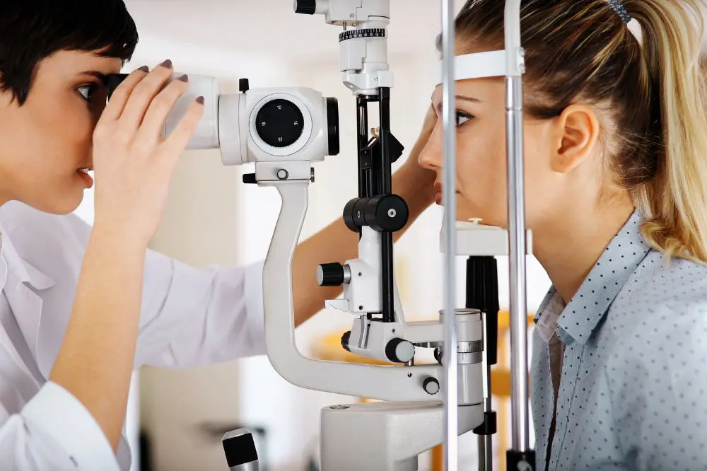 An eye doctor performs an exam on a young woman to see if she's a good candidate for LASIK eye surgery or PRK.