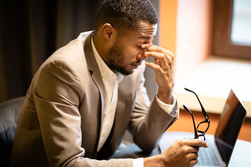 An attractive black man in a suit contemplates getting LASIK in Atlanta.